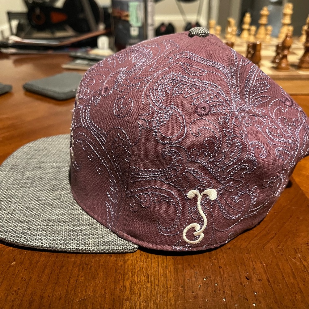 Purple and grey Grassroots hat designed by Randall Robert’s.